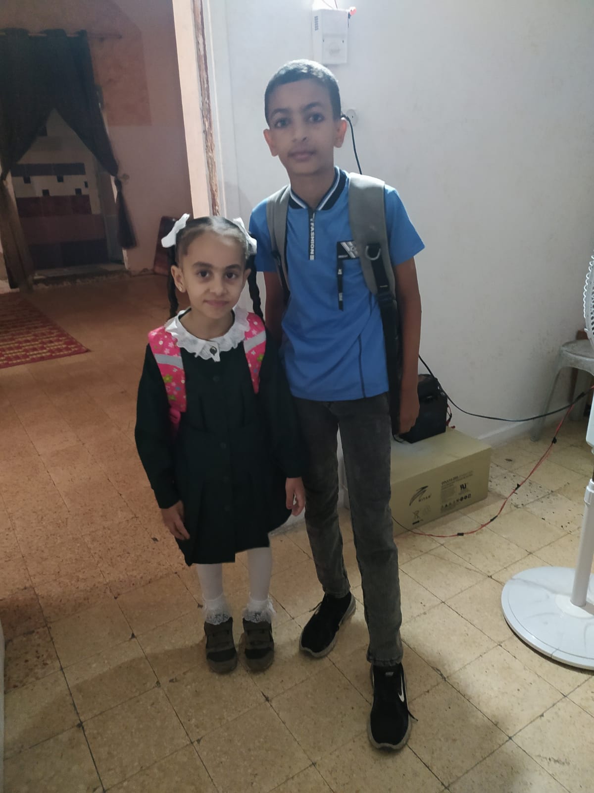 Two of Afnan's children in school uniforms